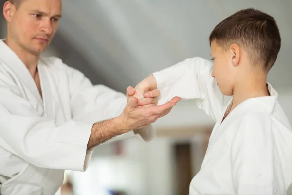 잘 생긴 남자 가르치는 작은 소년 aikido 운동 — 스톡 사진