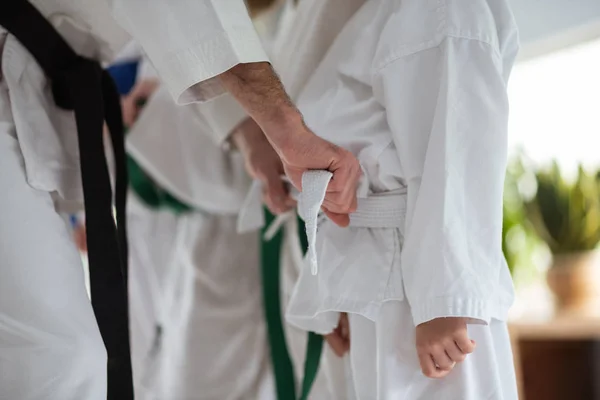 Treinador de aikido útil amarrando cinto para seu aluno — Fotografia de Stock