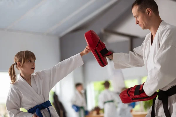 Girl with ponytails feeling serious while practicing with trainer — Stock Photo, Image