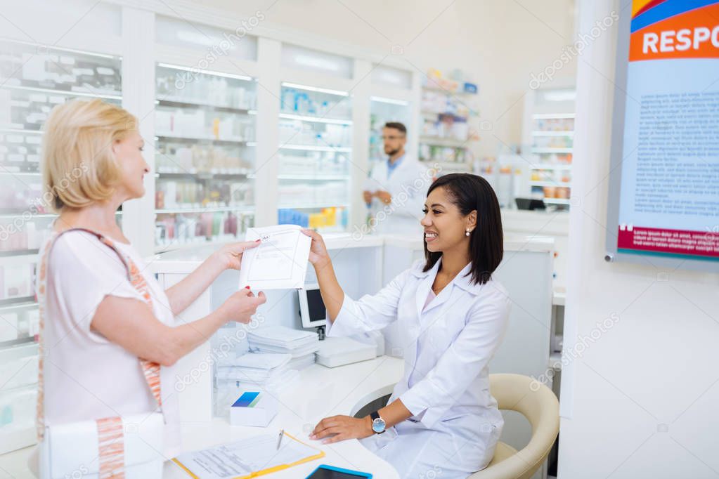 Kind blonde woman reading certificate on medicine