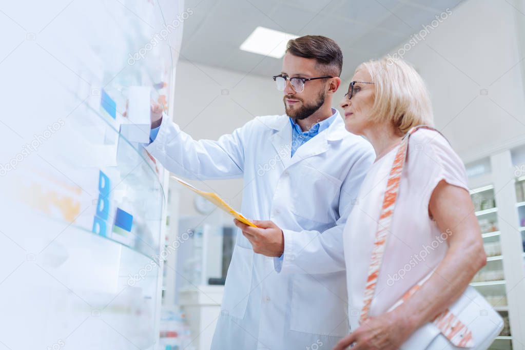 Attentive bearded male person working in drug store