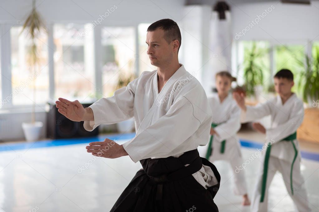 Young experienced aikido trainer showing his pupils movements