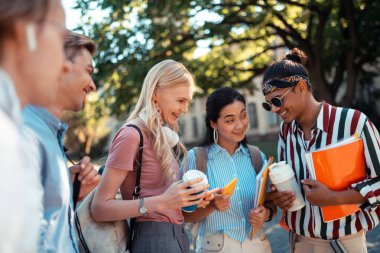 Birbirlerine ev ödevlerini soran öğrenciler.