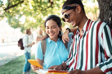 Üniversite molaları sırasında gülen kız ve erkek.