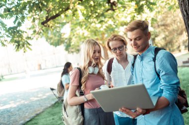 Üç grup arkadaşı projeye hazırlanıyor.