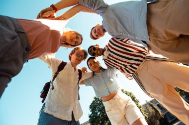 Birbirlerine sarılan öğrenciler bir daire oluşturarak.