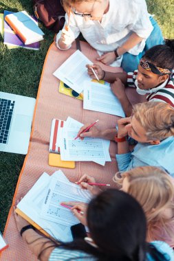 Açık havada test çözen öğrenci grubu.