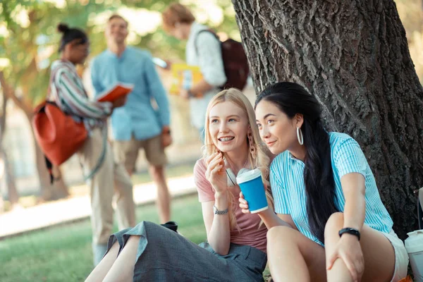 Två tjejer pratar om sina groupmates i fronten. — Stockfoto