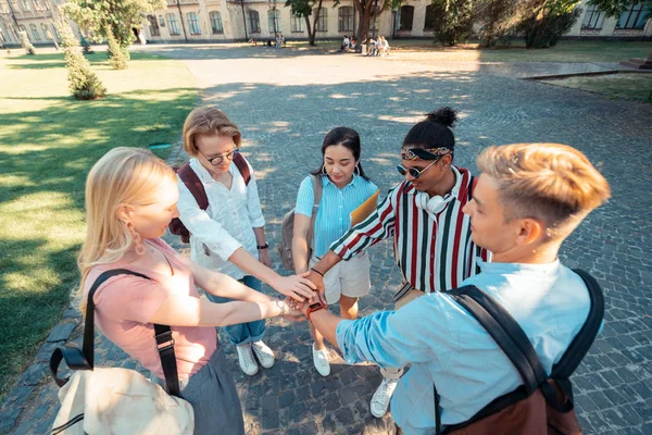 Schüler halten Händchen und bilden einen Kreis auf dem Hof. — Stockfoto