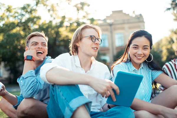 Tre sorridenti compagni di gruppo si rilassano dopo le lezioni all'aperto . — Foto Stock