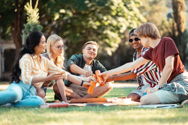 Glada studenter klingande deras pop burkar med drinkar. — Stockfoto