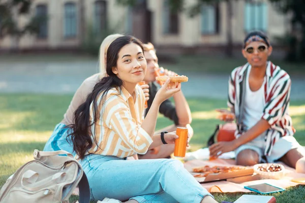 Gyönyörű lány eszik vele csoporttársak a piknik. — Stock Fotó