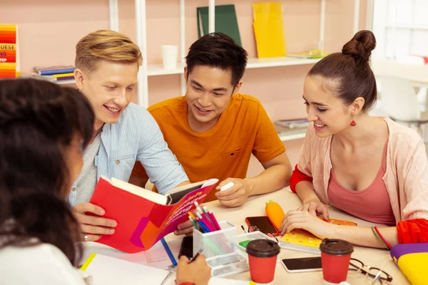 Positiva glada internationella studenter läsa bok före tentamen — Stockfoto