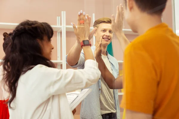 Cheerful young people celebrating their good results — Stock Photo, Image