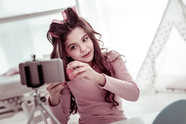 Deliziato ragazza positiva utilizzando i suoi bigodini capelli — Foto Stock