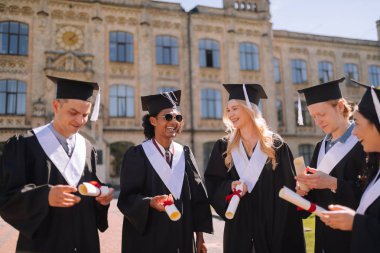 Neşeli mezun öğrenciler diplomalarına sahip olmaktan memnun.