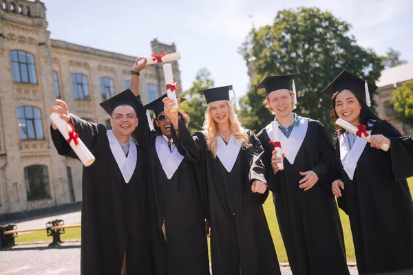 Веселі студенти святкують випуск з університету . — стокове фото