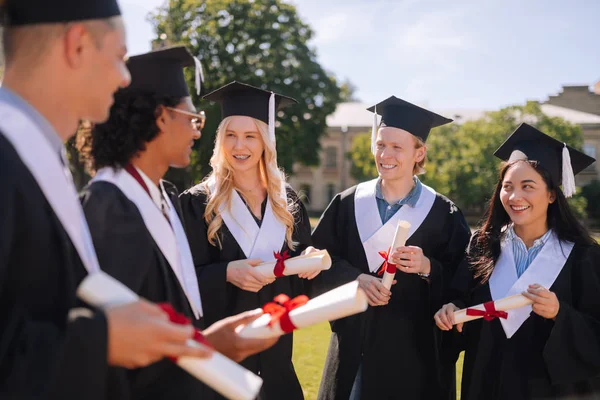 Gelukkige afgestudeerden praten over hun toekomstige plannen. — Stockfoto