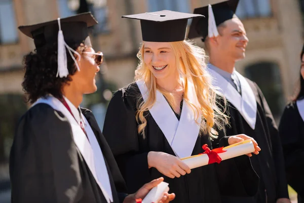 Vrolijk meisje praat met haar groupmate tijdens het afstuderen. — Stockfoto