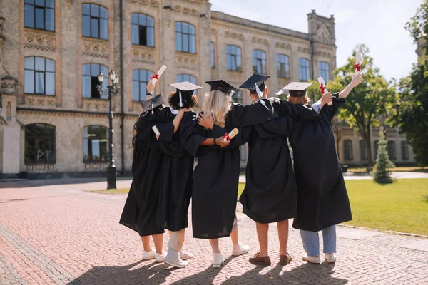 Graduados olhando para sua universidade pela última vez . — Fotografia de Stock