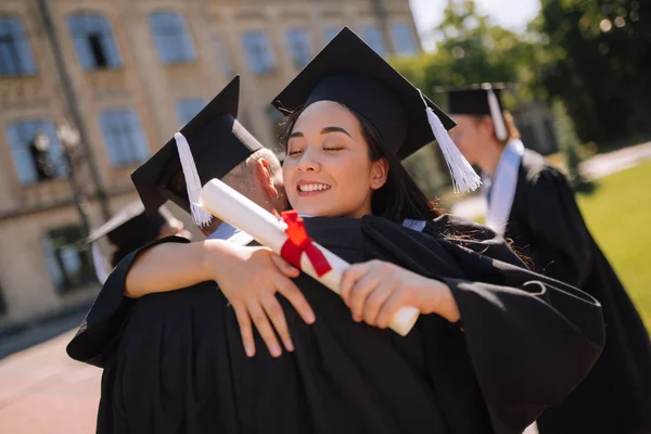 Zwei glückliche Mitschüler, die sich bei ihrer Abschlussfeier umarmen. — Stockfoto