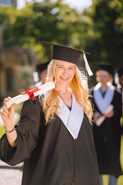 Щаслива дівчина, що показує диплом своїм друзям . — стокове фото