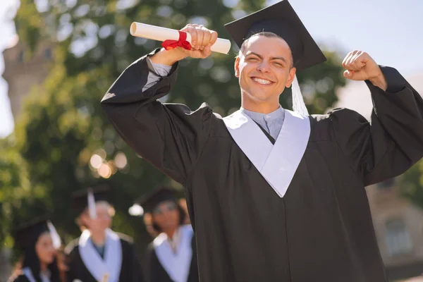 Vidám fiú, hogy boldog, hogy diplomával az egyetemen. — Stock Fotó