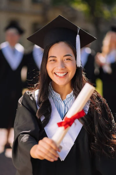 Happy girl showing her diploma to everyone. — Stock Photo, Image