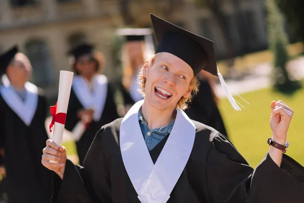 Feliz menino ruivo sendo feliz graduando-se da universidade . — Fotografia de Stock