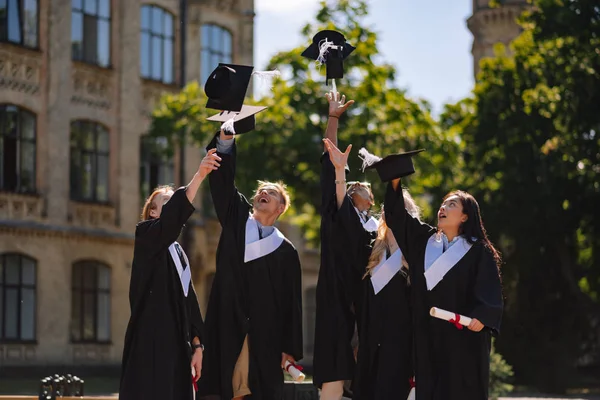 Les diplômés essayant d'attraper leurs maîtres casquettes . — Photo