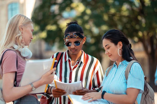 Dönem ödevlerini kontrol etmek için birbirlerine yardım edinen öğrenciler.