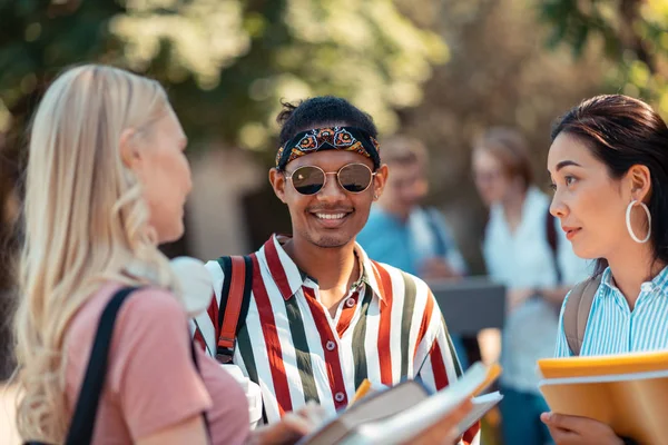 Neşeli çocuk onun konuşan grup arkadaşları arasında ayakta.