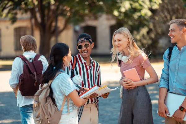 Grupp av studenter skämtar på universitets gården. — Stockfoto