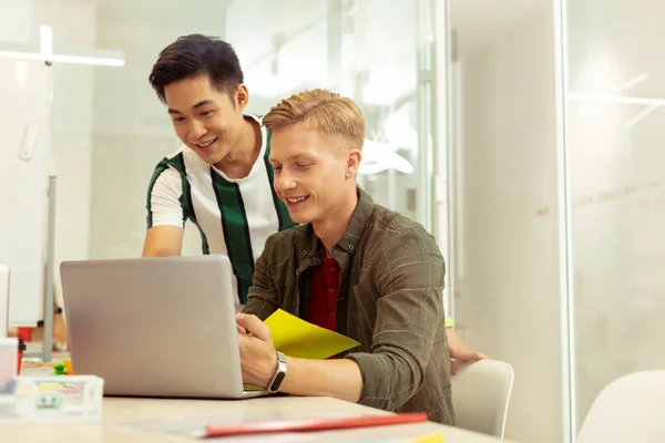 Freundlicher asiatischer Mann zeigt auf Personal Computer — Stockfoto