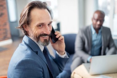 Çalışırken eşinden telefon almaktan mutlu hisseden işadamı