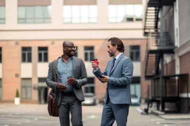 İşadamı çalışanıyla konuşuyor ve kahve içiyor