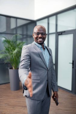 İş ortağını selamlarken gülümseyen işadamı