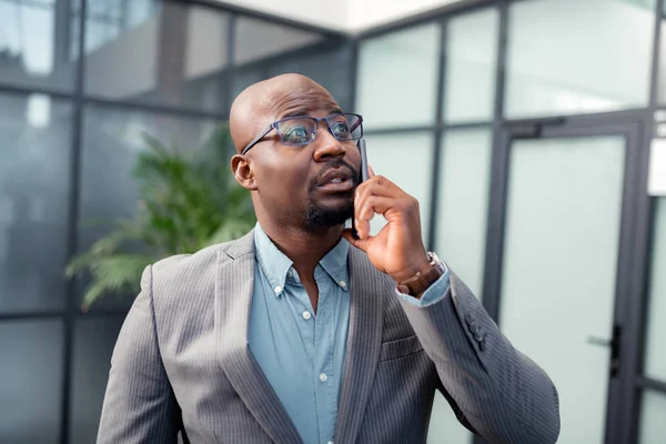 Hombre barbudo de piel oscura llamando a un socio de negocios desde la oficina — Foto de Stock