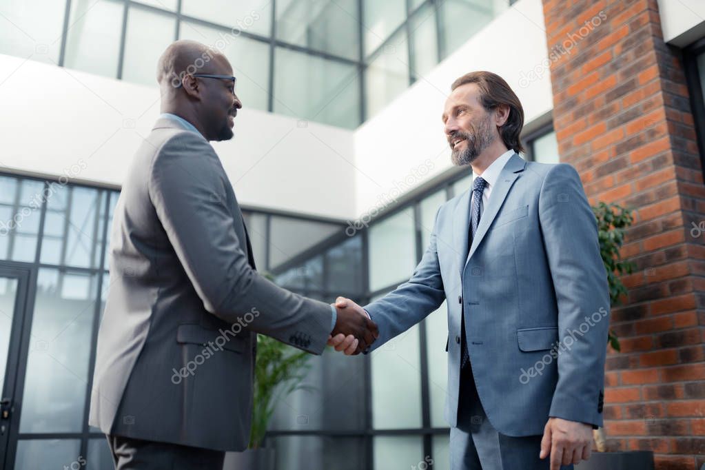 Man smiling while meeting his African-American investor