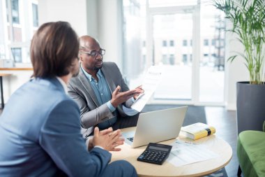 Toplantı sırasında patrona belgeleri gösteren çalışan