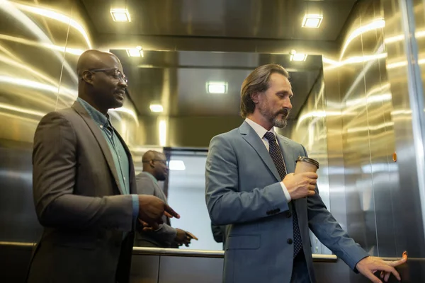 エレベーターでボタンを押す灰色の成熟したビジネスマン — ストック写真
