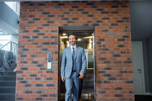 Hombre de negocios de pelo gris que usa traje y corbata sintiéndose motivado — Foto de Stock