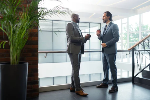 Dark-skinned zakenman koffie drinken met zijn zakenpartner — Stockfoto