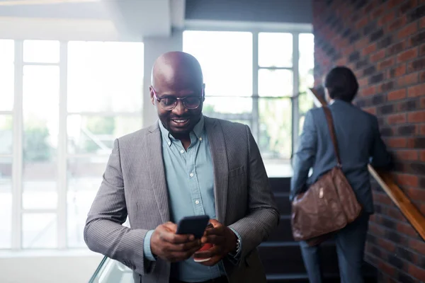 Hombre de negocios de piel oscura con gafas sonriendo mientras lee el mensaje — Foto de Stock