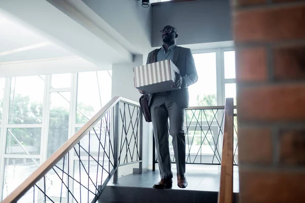 Kontorsarbetare lämnar kontoret med sin låda efter att ha fått sparken — Stockfoto