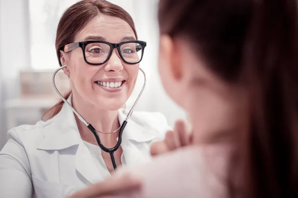Обличчя гарної жінки-лікаря, що стоїть біля пацієнта — стокове фото