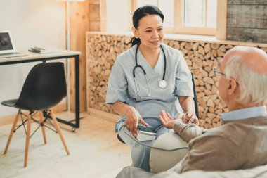 Kan basıncı nı okuyan mavi üniformalı koyu saçlı kadın