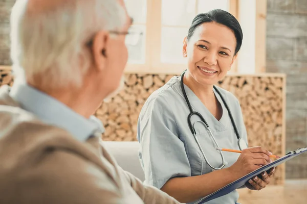 Pretty doctor with stethoscope on her neck listing complaints