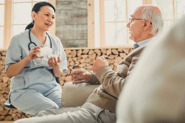 Przyjemna Ciemnowłosa kobieta na niebiesko pewnie rozmawia z pacjentem — Zdjęcie stockowe