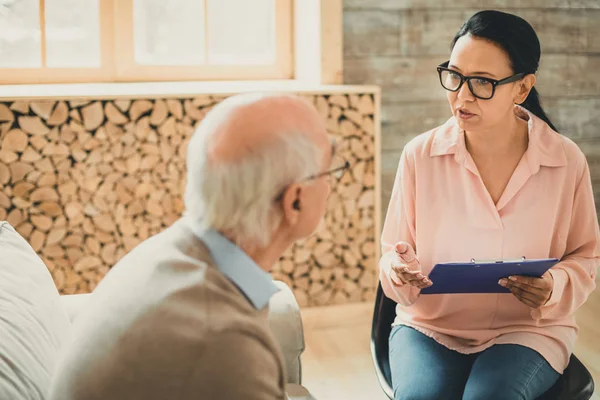 Woman in pink blouse having important conversation with old man